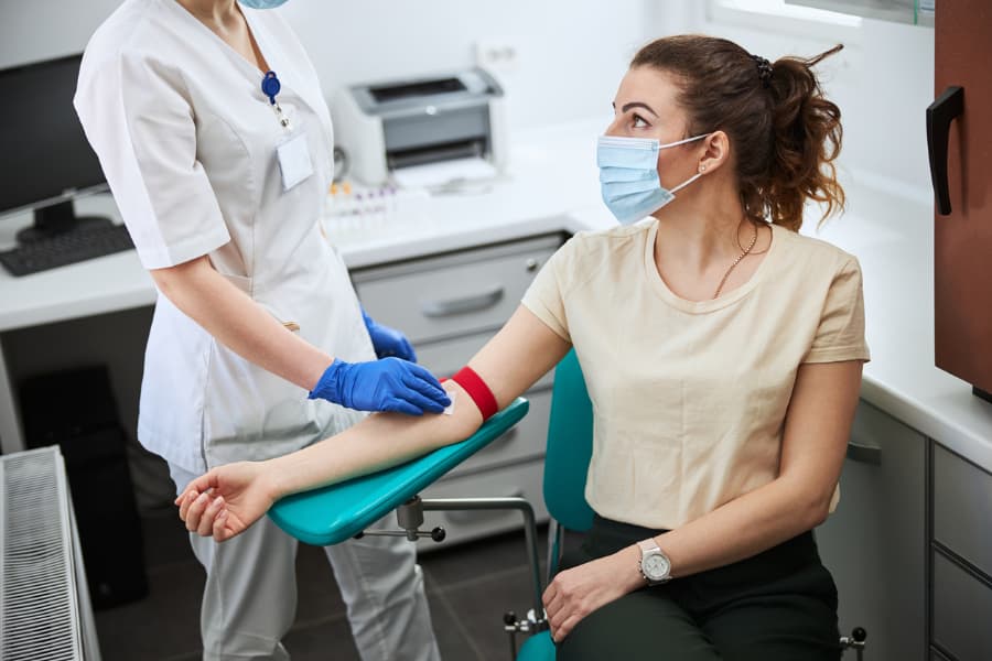a nurse prepares a womans arm for a blood draw
